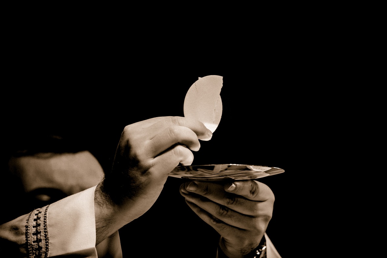 Priest's hands raising the host up during Liturgy of the Eucharist